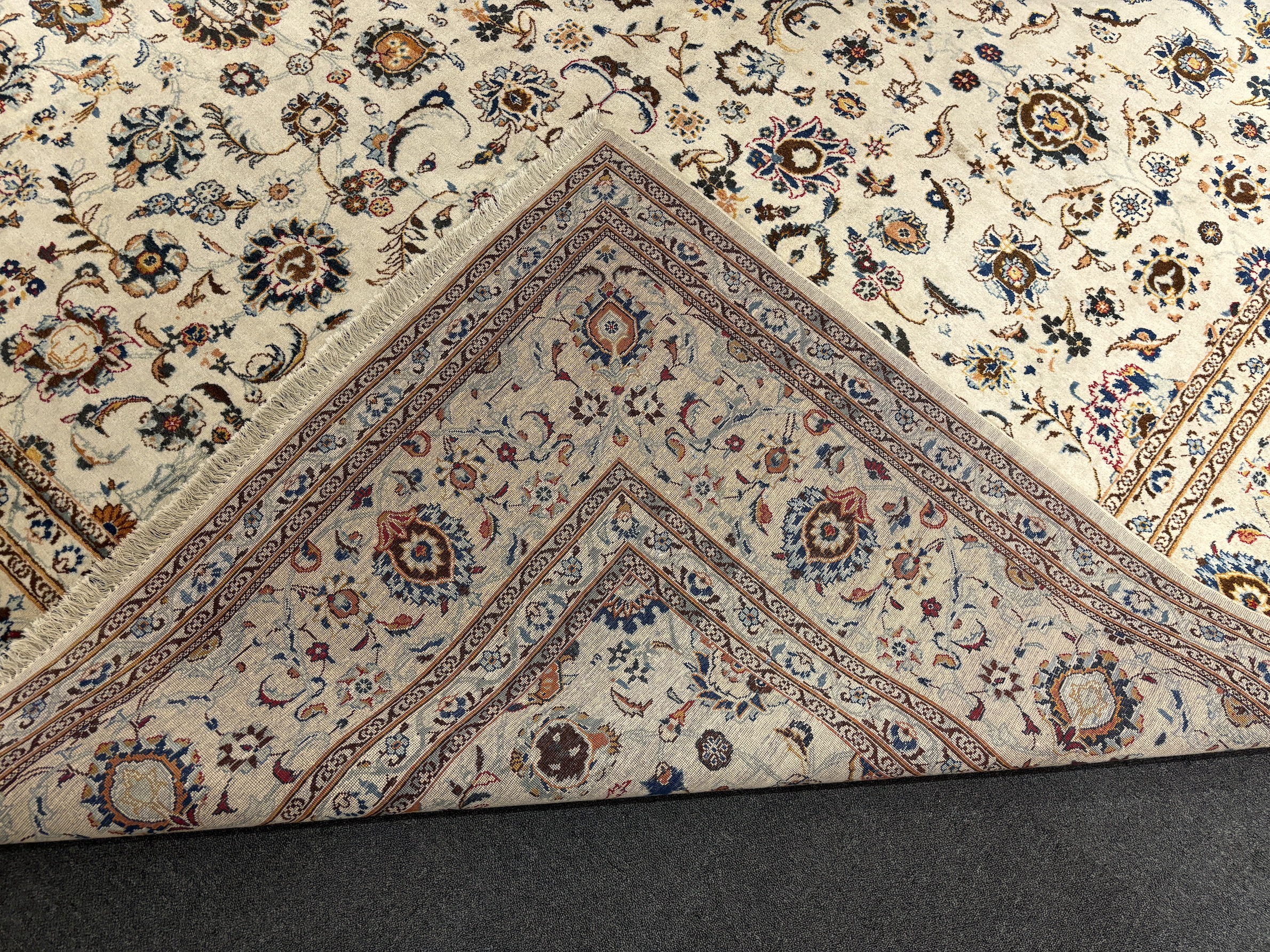 A Kashan ivory ground carpet, central field of foliate motifs, multi bordered, 400 x 308cm, Please note this lot attracts an additional import tax of 5% on the hammer price